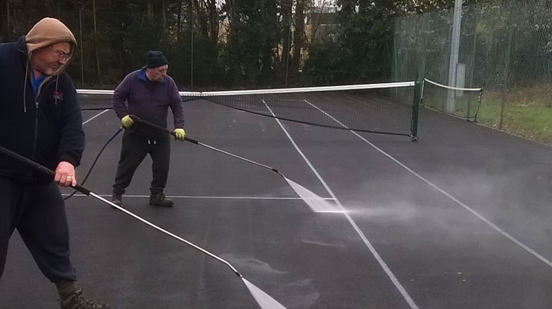 Pressure washing the tennis court surface is a critical step that involves using high-pressure water