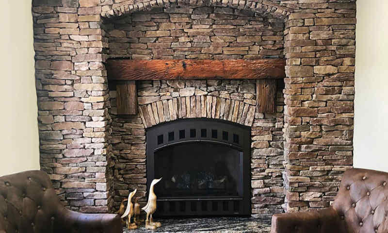 Fireplace surrounds with stone accents add a touch of elegance and visual appeal to interior walls